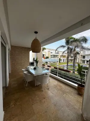 a living room with a table and a large window at Les Perles de Tamaris Beach access Pools in Casablanca
