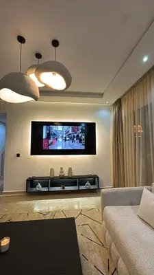 a living room with a couch and a flat screen tv at Les Perles de Tamaris Beach access Pools in Casablanca