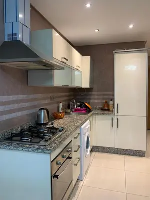 a kitchen with white cabinets and a stove top oven at Chic & secure in Casablanca