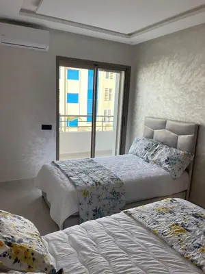 a bedroom with two beds and a window at Appartement Luxueux Mer & Piscine in Mansouria