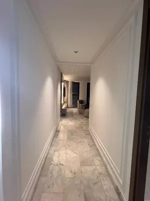 a hallway with white walls and a tile floor at Confort Urbain Casablanca Vue Accès Gare Casa Port in Casablanca