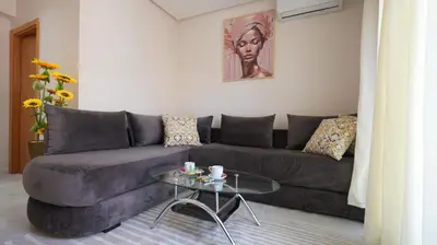 a living room with a couch and a glass table at Panoramique Studio a casablanca in Casablanca