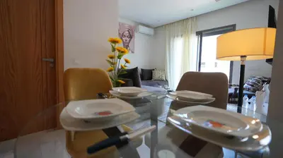 a dining room with a glass table and chairs at Panoramique Studio a casablanca in Casablanca