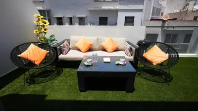 a couch and two chairs and a table on a balcony at Panoramique Studio a casablanca in Casablanca