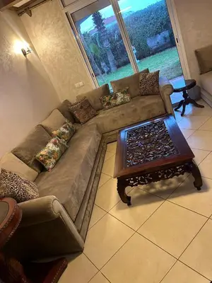a living room with a couch and a table at Appartement à Garden Beach , Sidi Rahal in Sidi Rahal