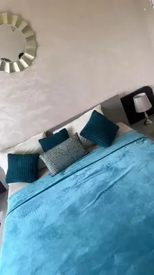 a bed with blue pillows on it in a bedroom at Appartement à Garden Beach , Sidi Rahal in Sidi Rahal