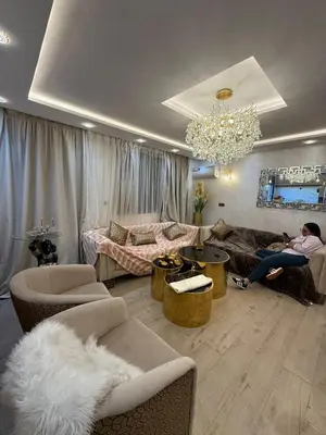 a living room with two people sitting on couches at Comfortable apartment temara in Temara