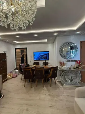 a dining room with a table and chairs and a chandelier at Comfortable apartment temara in Temara