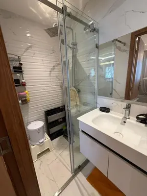 a bathroom with a glass shower and a sink at Comfortable apartment temara in Temara