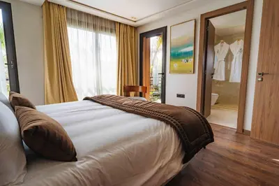 a bedroom with a large bed and a bathroom at Luxury Villa Jack Beach Resort Pool & Seaview in Tamaris