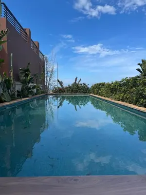 a swimming pool with blue water in front of a building at Luxury Villa Jack Beach Resort Pool & Seaview in Tamaris