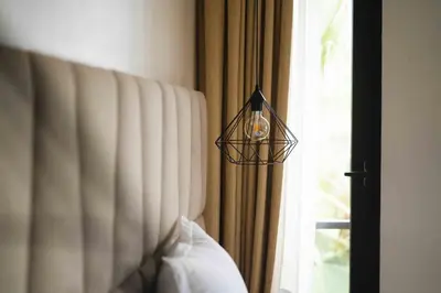 a lamp hanging over a bed next to a window at Luxury Villa Jack Beach Resort Pool & Seaview in Tamaris