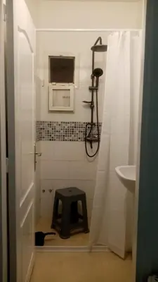 a bathroom with a shower with a stool in it at Appartement neuf, propre et ensoleillé in Temara