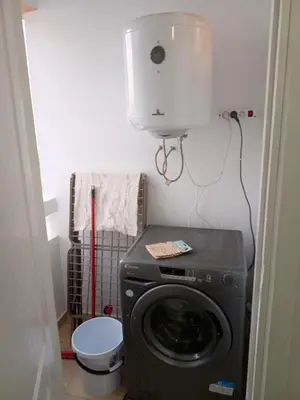 a laundry room with a washing machine and a toilet at Appartement neuf, propre et ensoleillé in Temara