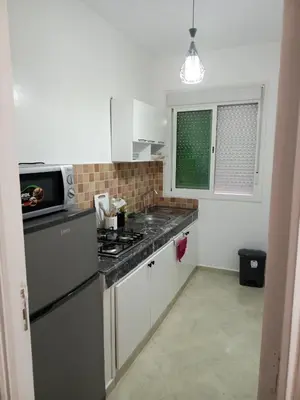 a small kitchen with a stove and a refrigerator at Appartement neuf, propre et ensoleillé in Temara