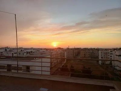 a view of the sunset from a balcony of a building at Appartement neuf, propre et ensoleillé in Temara