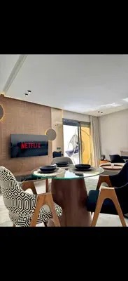 a living room with a table and chairs in a room at Arena Maarif in Casablanca