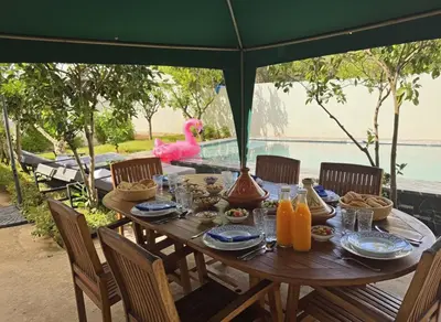 a table with food and a pink flamingo in the background at private villa with swimming pool in Rabat