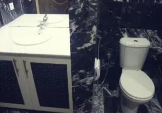 a bathroom with a white toilet and a sink at Rabat Apartments in Rabat