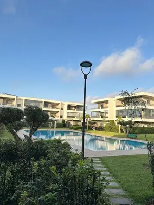 a street light in front of a building with a pool at Logement luxueux avec 2 piscines in Dar Hamida