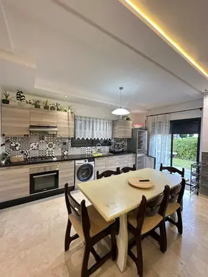 a kitchen and dining room with a table and chairs at Logement luxueux avec 2 piscines in Dar Hamida