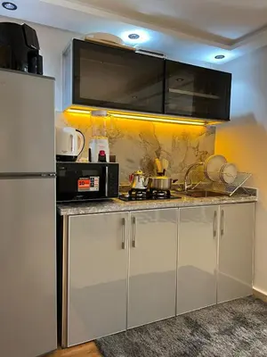 a kitchen with a counter with a microwave and a refrigerator at Villa 1 Corniche, Seaside Stay at Carrousel Mall, Walk Everywhere in Rabat