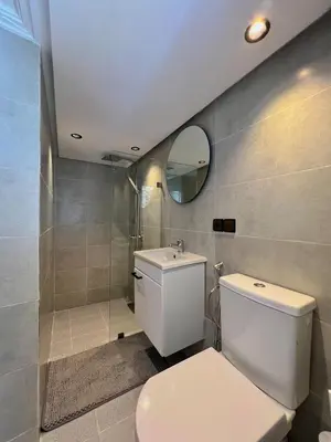 a bathroom with a white toilet and a mirror at Villa 1 Corniche, Seaside Stay at Carrousel Mall, Walk Everywhere in Rabat