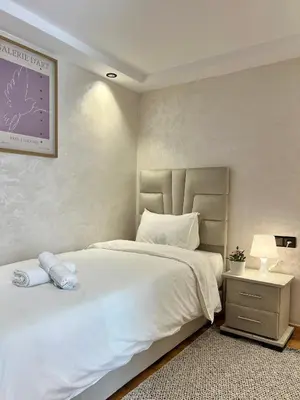 a bedroom with a large white bed and a lamp at C2, Modern Charm apartment Facing Carrousel with Ocean View in Rabat