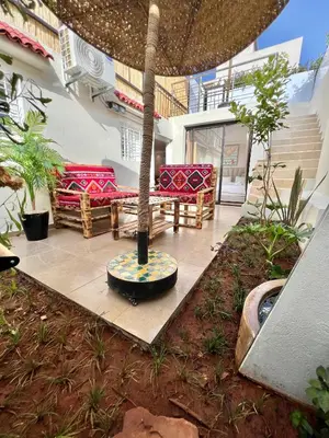a courtyard with a table and benches in a building at C2, Modern Charm apartment Facing Carrousel with Ocean View in Rabat