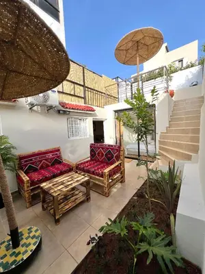 a patio with two chairs and a table and stairs at C2, Modern Charm apartment Facing Carrousel with Ocean View in Rabat