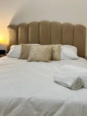 a large bed with white sheets and pillows at Appartement chic - Princesses in Casablanca