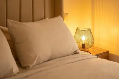 a bed with a pillow and a lamp on a night stand at Studio chic- les princesses Maarif in Casablanca