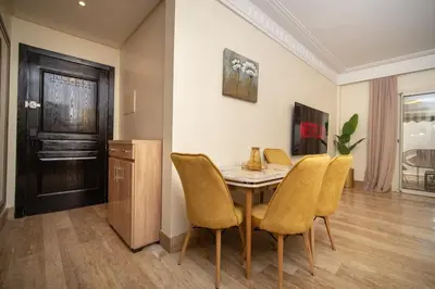 a dining room with a table and yellow chairs at Studio chic- les princesses Maarif in Casablanca