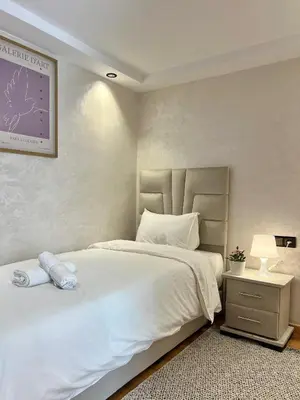 a bedroom with a large white bed and a lamp at Villa 3 Corniche, Charming Seaside Villa with Jacuzzi, Carrousel Mall Rabat in Rabat