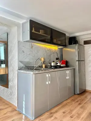 a kitchen with gray cabinets and a stainless steel refrigerator at Villa 3 Corniche, Charming Seaside Villa with Jacuzzi, Carrousel Mall Rabat in Rabat