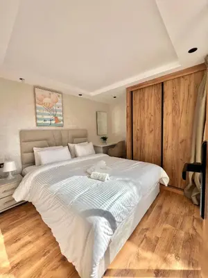 a large white bed in a bedroom with wooden floors at Villa 3 Corniche, Charming Seaside Villa with Jacuzzi, Carrousel Mall Rabat in Rabat