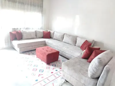 a living room with a white couch and red pillows at Charmant appartement à Casablanca Près tram & gare in Casablanca
