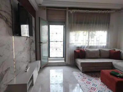 a living room with a couch and a window at Charmant appartement à Casablanca Près tram & gare in Casablanca