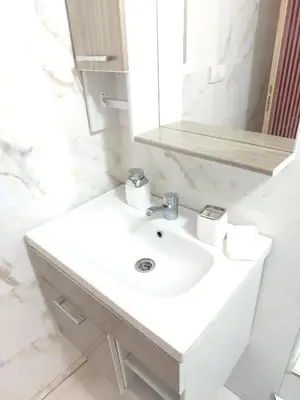 a bathroom with a white sink and a mirror at Charmant appartement à Casablanca Près tram & gare in Casablanca