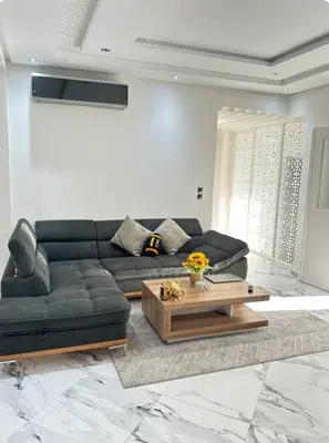 a living room with a black couch and a coffee table at Rabat Agdal apartment in Rabat