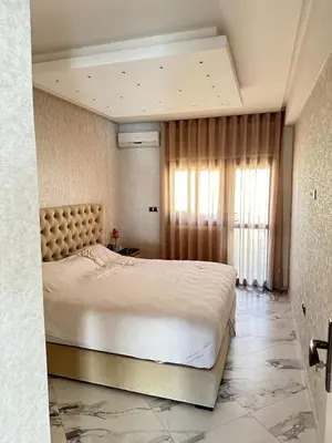 a bedroom with a large bed and a window at Rabat Agdal apartment in Rabat
