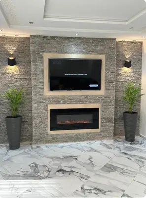 a living room with a fireplace with a tv on a wall at Rabat Agdal apartment in Rabat