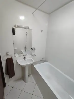a white bathroom with a sink and a bath tub at Apartment 2 rooms in Agdal in Rabat