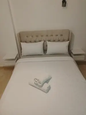 a bed with a white blanket and pillows on it at Apartment 2 rooms in Agdal in Rabat