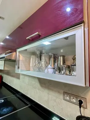 a cabinet with many glass vases in it at 2-bedroom duplex for rent in Temara