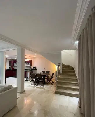 a living room and dining room with a table and chairs at 2-bedroom duplex for rent in Temara