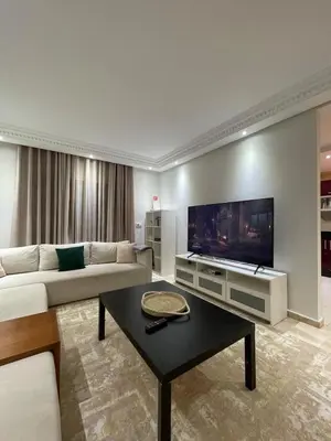 a living room with a couch and a flat screen tv at 2-bedroom duplex for rent in Temara