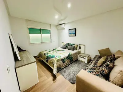 a bedroom with a bed and a couch at Villa de luxe avec piscine et jardin privés in Temara