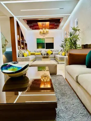a living room with a couch and a table at Villa de luxe avec piscine et jardin privés in Temara