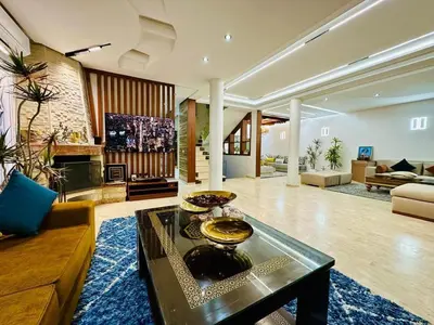 a living room with a couch and a table at Villa de luxe avec piscine et jardin privés in Temara